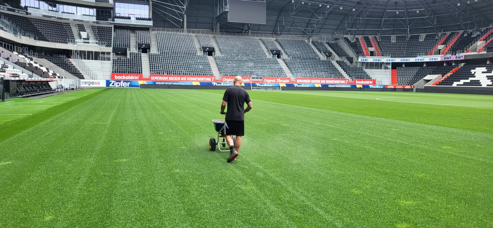 Greenkeeper bei der Rasenpflege im Stadion